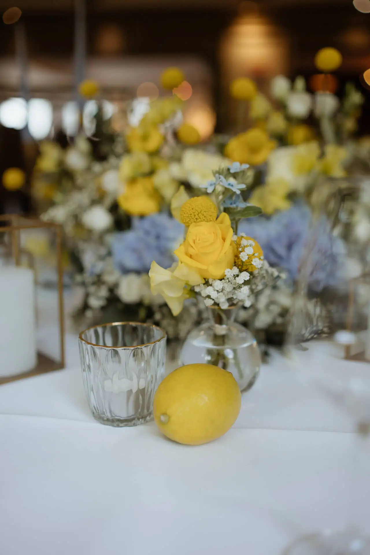 Gelbe Blumen und Zitrone auf Tisch