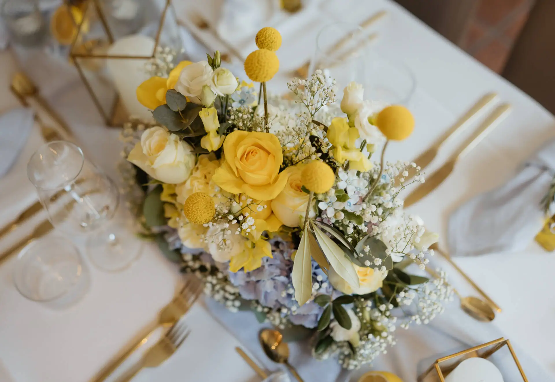 Blumenarrangement auf einem gedeckten Tisch