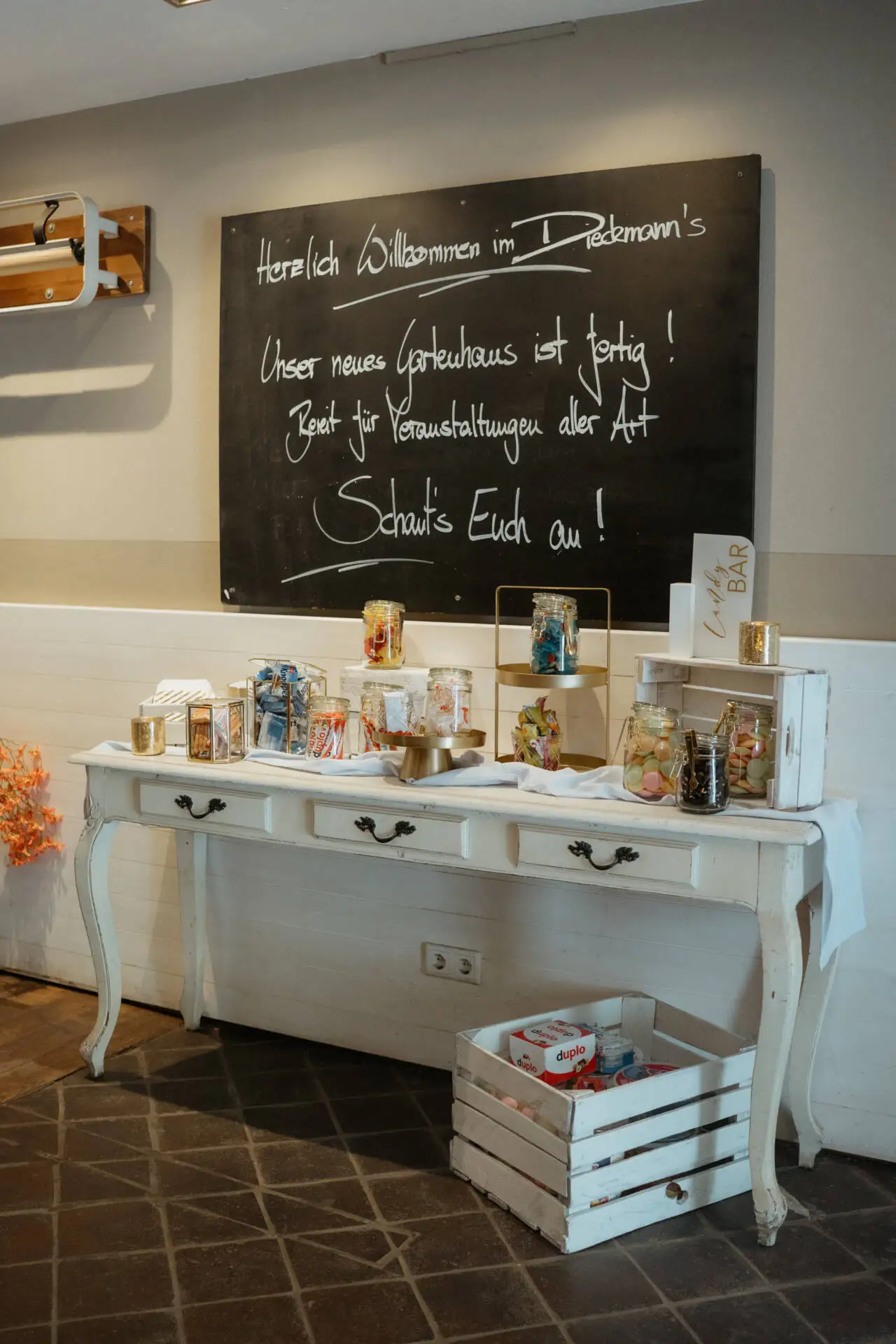 Willkommensschild und Süßigkeitentisch in Café.