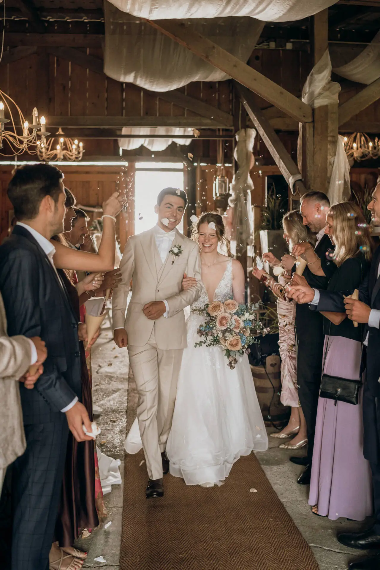 Brautpaar bei rustikaler Hochzeitsfeier mit Seifenblasen