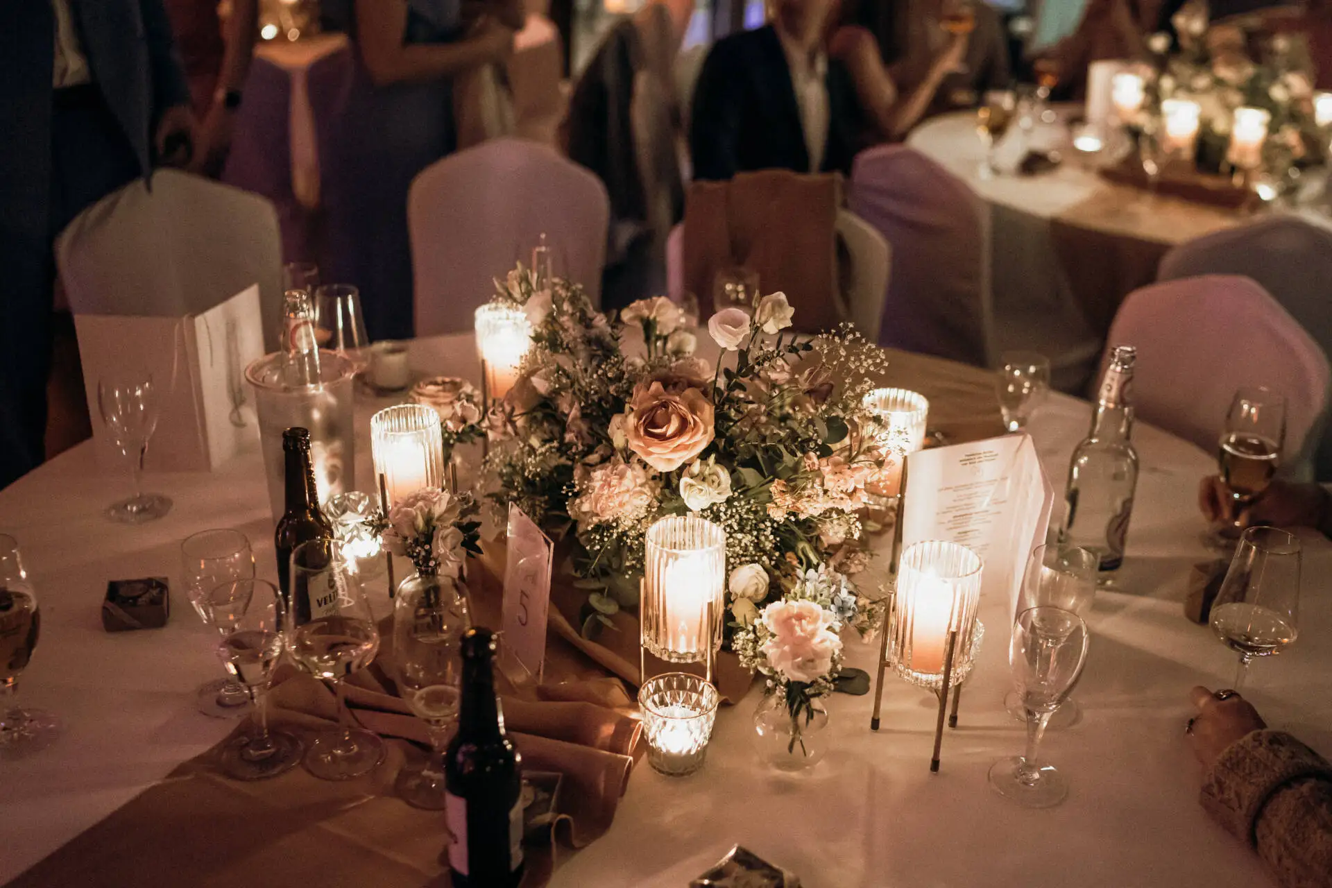 Hochzeitstisch mit Blumen und Kerzen dekoriert.