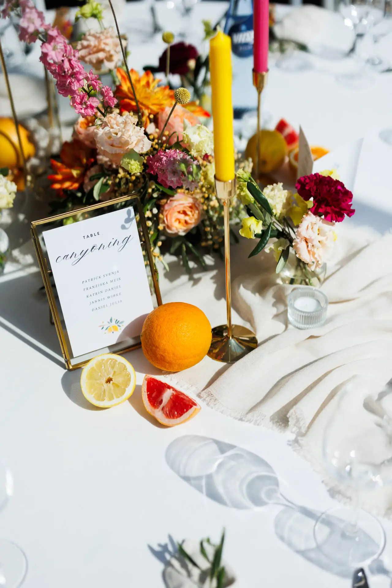 Hochzeitstisch mit Blumen, Kerzen und Obst.
