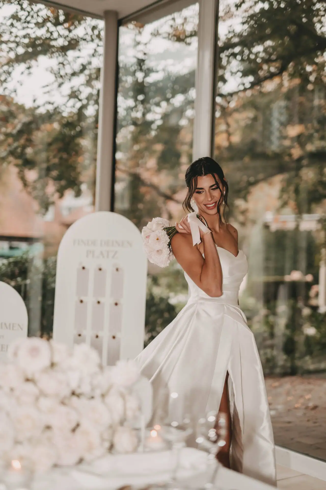 Braut in weißem Kleid mit Blumenstrauß