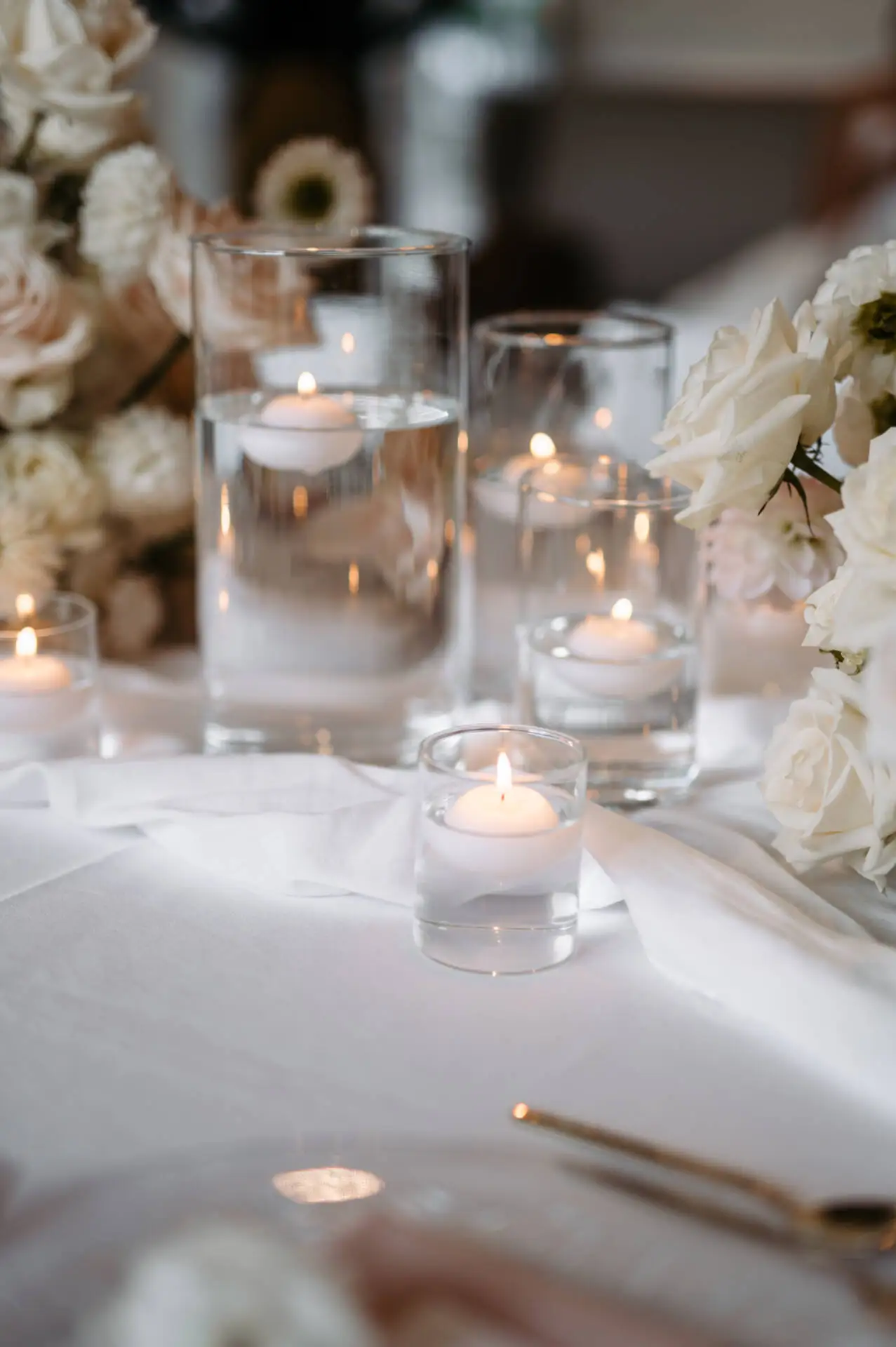 Kerzen und weiße Blumen auf Tischdeko