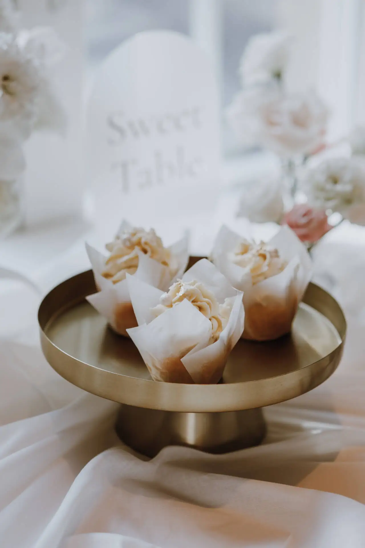 Vier Cupcakes auf goldener Tortenplatte