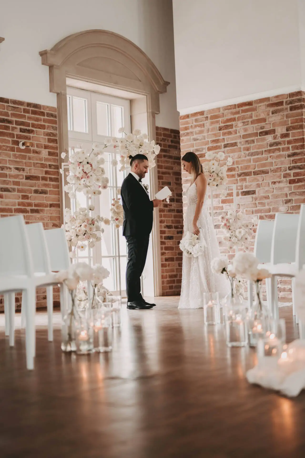 Brautpaar bei der Trauung mit Blumen und Kerzen.