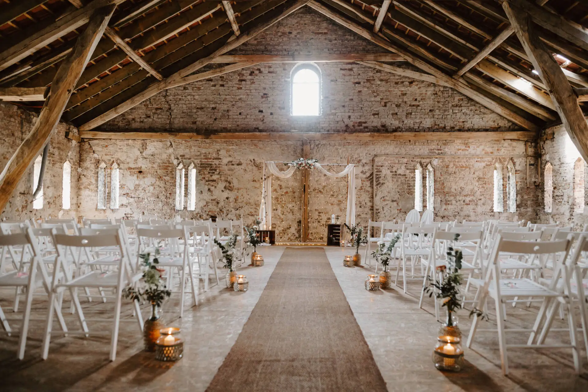 Rustikale Hochzeitsscheune mit Stühlen und Blumendekoration.