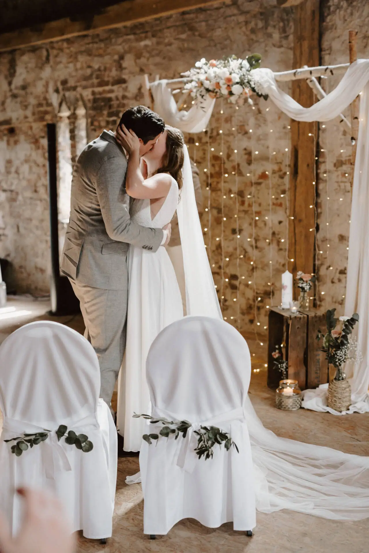 Hochzeitspaar bei der Trauung in rustikalem Ambiente.